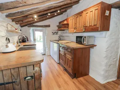 a kitchen with wooden cabinets and a counter top at Old Ty'n Y Wern in Bala