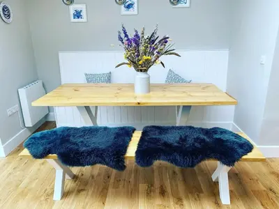 a wooden table with two blue cushions under a table at Gwel y Don 12 Tabenacle Street in Aberaeron