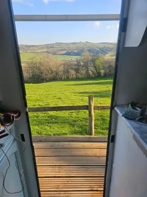 a door to a porch with a view of a field at Cosy Caravan Walkers Ramblers Fishermen Cyclists in Abermule