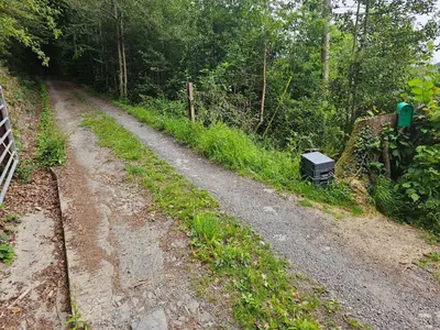 a dirt road with a black box on the side at Cosy Caravan Walkers Ramblers Fishermen Cyclists in Abermule