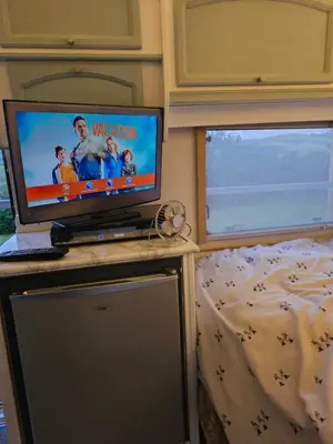 a television sitting on a table in a bedroom at Cosy Caravan Walkers Ramblers Fishermen Cyclists in Abermule