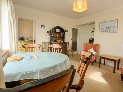 a living room with a table and chairs at Tegawelon in Harlech