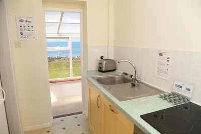 a small kitchen with a sink and a window at Tegawelon in Harlech
