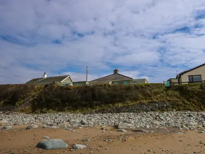 a house on top of a hill next to a beach at Tegawelon in Harlech