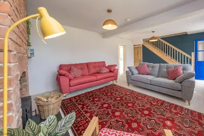 a living room with two couches and a rug at Glanaber in Dyffryn