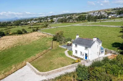 an aerial view of a white house in a field at Glanaber in Dyffryn