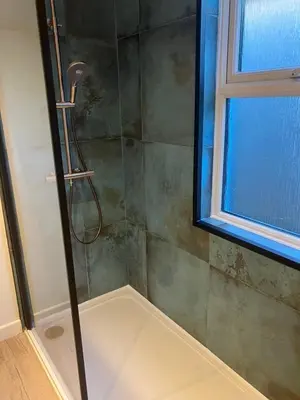 a shower with a glass door next to a window at Blue Lodge - by the sea, sauna, BBQ, private garden and parking in Aberystwyth