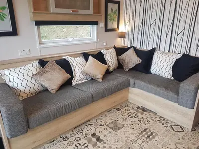 a couch with pillows on it in a living room at POD4 Family Glamping with seaview & Wi-Fi in Llwyngwril
