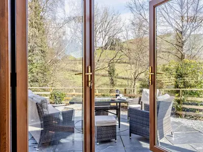 a glass door leading to a patio with a table and chairs at 4 Bed in Llanidloes oc-95968 in Van