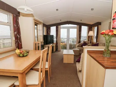 a kitchen and living room with a table and a couch at 21 Bay View in New Quay