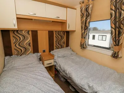 two beds in a small room with a window at 21 Bay View in New Quay