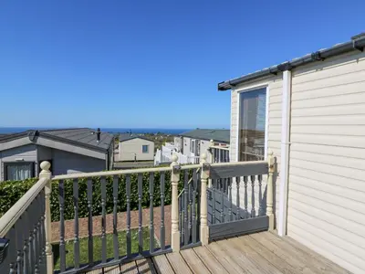 a balcony with a wooden railing and a house at 21 Bay View in New Quay