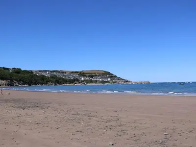 a sandy beach with the ocean in the background at 21 Bay View in New Quay