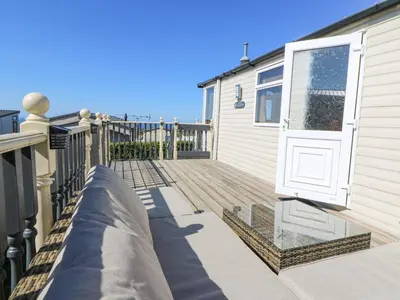 a wooden deck with a white door on a house at 21 Bay View in New Quay