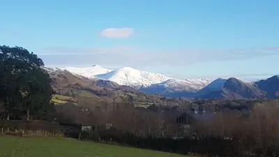 a view of a snow covered mountain in a field at POD6 Family Glamping with seaview & Wi-Fi in Llwyngwril