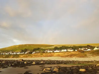 a group of houses on a hill next to a river at POD6 Family Glamping with seaview & Wi-Fi in Llwyngwril