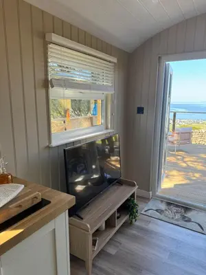 a living room with a fish tank and a window at coastal view shepherds hut with hot tub in Llanfair