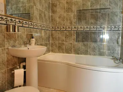 a bathroom with a sink and a bath tub and a sink at Llaethdy Rachel Lampeter in Aberaeron