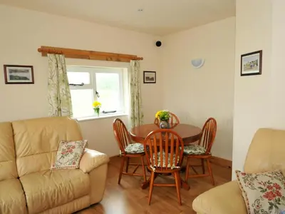 a living room with a table and chairs and a couch at Llaethdy Rachel Lampeter in Aberaeron