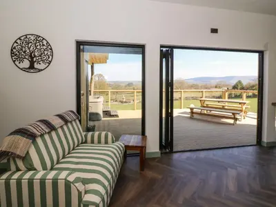 a living room with a couch and a sliding glass door at Llety Cariad in Llandrindod Wells