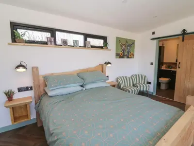 a bedroom with a bed with a blue comforter at Bryn Hafod in Llandrindod Wells