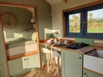 a kitchen with a counter with a sink and a window at Fir Tree Shepherd's Hut in Llanon