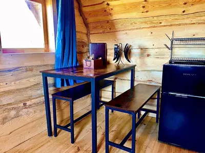a wooden table and a chair in a room at The Viking Lodge with Sauna in Ystrad-Meurig