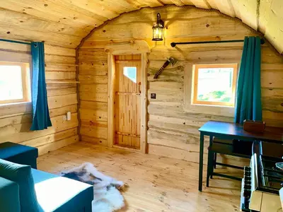 a log cabin with a table in a room at The Viking Lodge with Sauna in Ystrad-Meurig