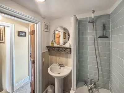 a bathroom with a sink and a toilet and a shower at Flo's Cottage in Kington