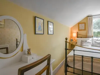 a bedroom with two bunk beds and a mirror at Flo's Cottage in Kington