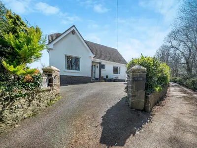 a white house with a driveway in front of it at Yr Encil in New Quay