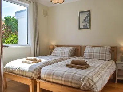 a bedroom with two beds with towels on them at Yr Encil in New Quay