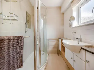 a bathroom with a shower toilet and a sink at Yr Encil in New Quay