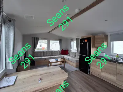 a living room with a couch and a table at Seans 291 sandy cove 041 in Barmouth
