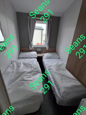 two beds in a room with neon green signs at Seans 291 sandy cove 041 in Barmouth