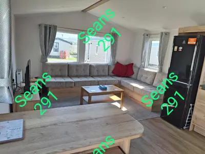 a living room with a couch and a refrigerator at Seans 291 sandy cove 041 in Barmouth
