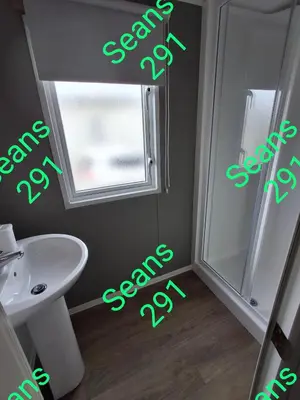 a bathroom with a toilet and a sink and a window at Seans 291 sandy cove 041 in Barmouth