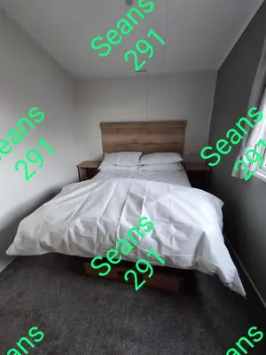 a bedroom with a bed with neon signs on it at Seans 291 sandy cove 041 in Barmouth