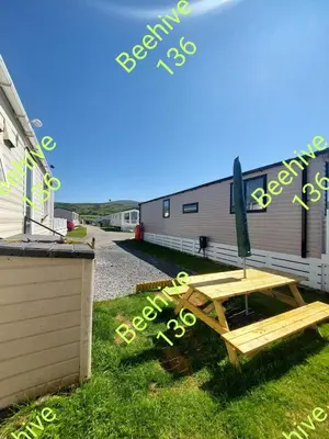 a picnic table in the grass next to a building at Beehive 136 snowdon summit 100 in Barmouth