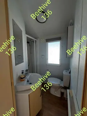 a bathroom with a sink and a toilet and a mirror at Beehive 136 snowdon summit 100 in Barmouth