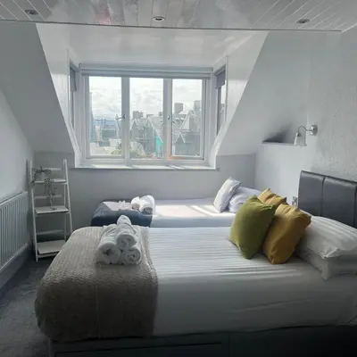 a bedroom with two beds and a window at gwesTY Guest House in Aberystwyth