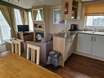 a kitchen and living room with a couch and a table at The Lookout 3 Bedroom Family Caravan Pet Friendly in Aberystwyth