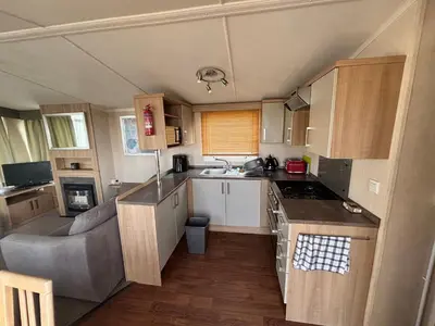 a small kitchen with a couch and a sink at The Lookout 3 Bedroom Family Caravan Pet Friendly in Aberystwyth