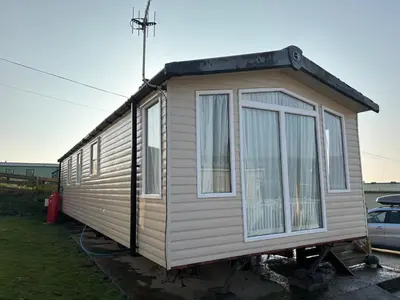 a tiny house on a stand in a yard at The Lookout 3 Bedroom Family Caravan Pet Friendly in Aberystwyth