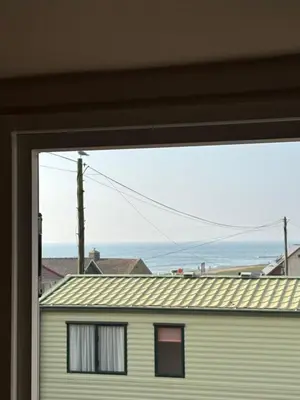 a window view of the ocean from a house at The Lookout 3 Bedroom Family Caravan Pet Friendly in Aberystwyth