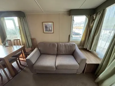 a living room with a couch and a table at The Lookout 3 Bedroom Family Caravan Pet Friendly in Aberystwyth