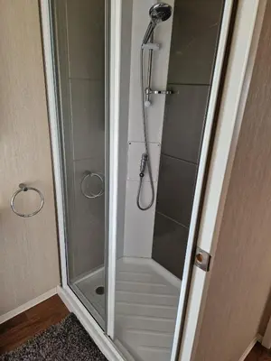 a shower with a glass door in a bathroom at The Lookout 3 Bedroom Family Caravan Pet Friendly in Aberystwyth