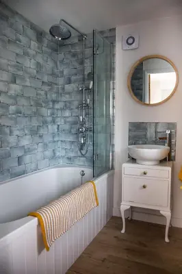a bathroom with a tub and a sink and a mirror at Beautiful Cabin Near Hay-on-Wye in Peterchurch