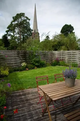 a wooden table and bench with a potted plant on it at Beautiful Cabin Near Hay-on-Wye in Peterchurch