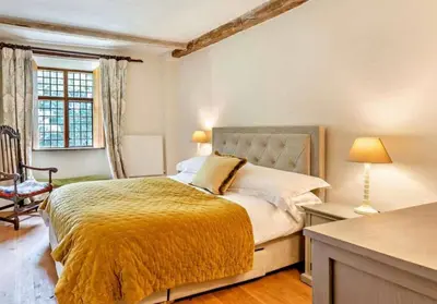 a bedroom with a bed and a chair and a window at Beautiful Brecon Beacon House in Llandovery